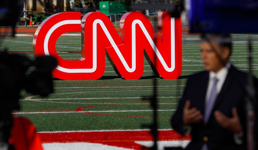 A journalist records video near a CNN sign on an athletic field outside the Clements Recreation Center where the CNN/New York Times will host the Democratic presidential primary debate at Otterbein University, Monday, Oct. 14, 2019, in Westerville, Ohio. (AP Photo/John Minchillo, File)