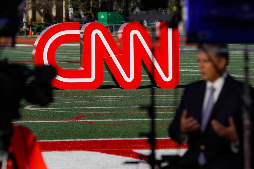 A journalist records video near a CNN sign on an athletic field outside the Clements Recreation Center where the CNN/New York Times will host the Democratic presidential primary debate at Otterbein University, Monday, Oct. 14, 2019, in Westerville, Ohio. (AP Photo/John Minchillo, File)