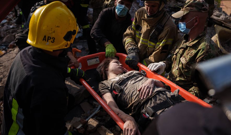 Locals and rescuers carry out an injured woman from a residential building destroyed in a Russian missile strike on Pryluky, Ukraine, Wednesday, Oct. 7, 2026. (AP Photo/Evgeniy Maloletka)