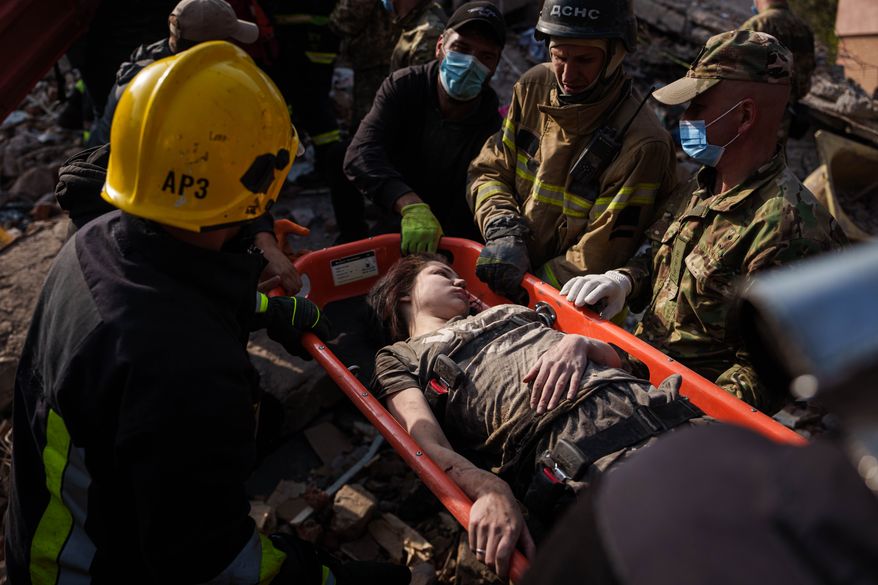 Locals and rescuers carry out an injured woman from a residential building destroyed in a Russian missile strike on Pryluky, Ukraine, Wednesday, Oct. 7, 2026. (AP Photo/Evgeniy Maloletka)
