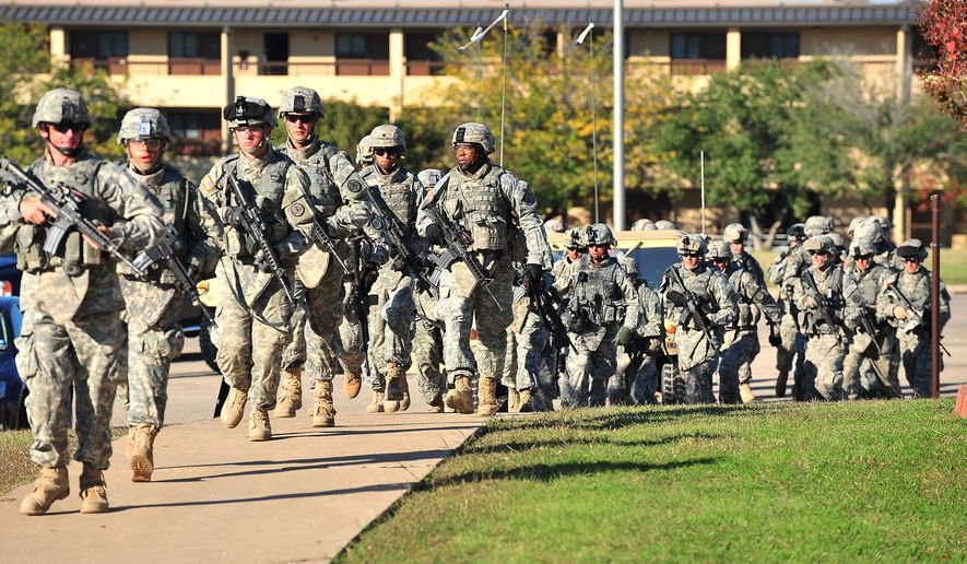 Soldiers from the 3rd Armored Cavalry Regiment storm the grounds of the Soldier Readiness Center to apprehend a mass shooter in Fort Hood, Texas, on Nov. 5, 2009. (David Morris/Killeen Daily Herald via AP, File)