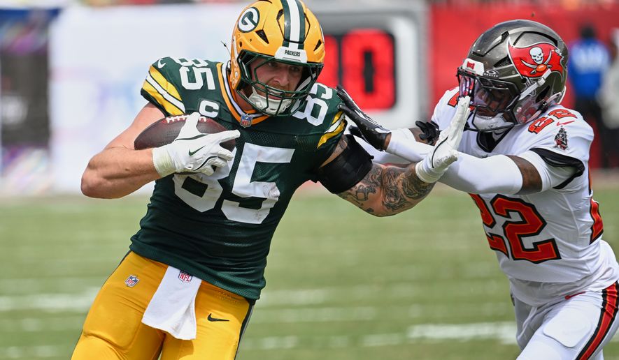 Tampa Bay Buccaneers cornerback Keionte Scott (22) grabs Green Bay Packers tight end Tucker Kraft (85) during the first half of an NFL football game in Tampa, Fla., Sunday, Oct. 4, 2026. (AP Photo/Jason Behnken)