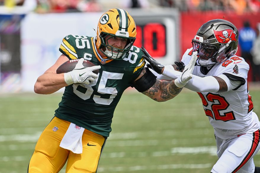 Tampa Bay Buccaneers cornerback Keionte Scott (22) grabs Green Bay Packers tight end Tucker Kraft (85) during the first half of an NFL football game in Tampa, Fla., Sunday, Oct. 4, 2026. (AP Photo/Jason Behnken)