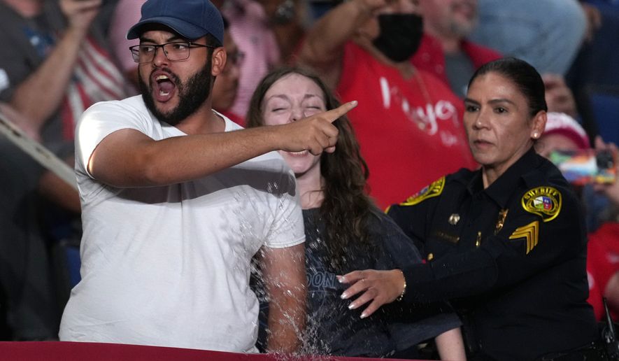 Police remove protesters as President Donald Trump speaks at a campaign rally at the Freeman Coliseum in San Antonio, Wednesday, Oct. 7, 2026. (AP Photo/Eric Gay)