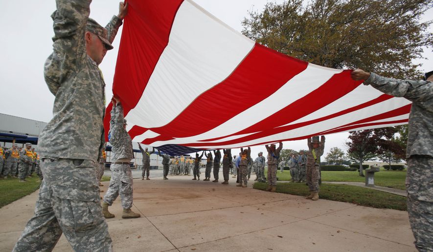 Soldiers from Fort Hood fold a American flag inside Fort Hood in Killeen, Texas, Monday, Nov. 9, 2009 in preparation for President Obama's planned visit on Tuesday. Army psychiatrist Maj. Nidal Malik Hasan is suspected of opening fire on fellow soldiers during a rampage that left 13 people dead on Thursday, Nov. 5, 2009. (AP Photo/Paul Sakuma)