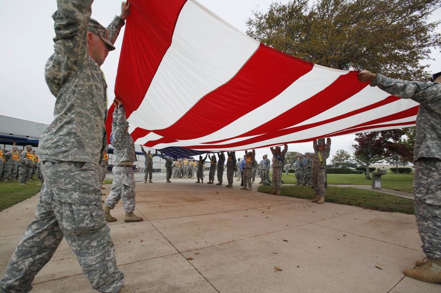 Soldiers from Fort Hood fold a American flag inside Fort Hood in Killeen, Texas, Monday, Nov. 9, 2009 in preparation for President Obama's planned visit on Tuesday. Army psychiatrist Maj. Nidal Malik Hasan is suspected of opening fire on fellow soldiers during a rampage that left 13 people dead on Thursday, Nov. 5, 2009. (AP Photo/Paul Sakuma)