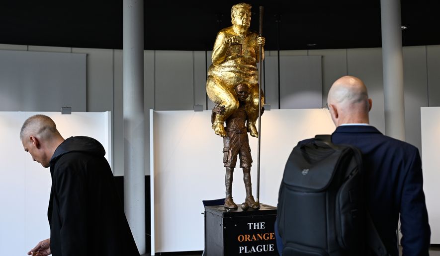 Visitors looks at a scupture titled "The Orange Plague" by Danish artist Jens Galschiot, depicting U.S. President Donald Trump, on display at the European Parliament building in Strasbourg, France, Wednesday Oct. 7, 2026. (AP Photo/Pascal Bastien)