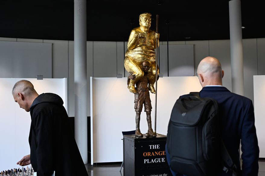 Visitors looks at a scupture titled "The Orange Plague" by Danish artist Jens Galschiot, depicting U.S. President Donald Trump, on display at the European Parliament building in Strasbourg, France, Wednesday Oct. 7, 2026. (AP Photo/Pascal Bastien)