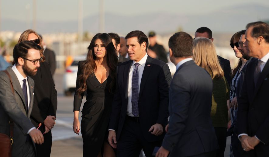 U.S. Secretary of State Marco Rubio, center, and U.S. Ambassador to Greece Kimberly Guilfoyle stand at Eleftherios Venizelos International Airport near Athens, Greece, before Rubio boards a plane , Thursday, Oct. 8, 2026. (AP Photo/Mark Schiefelbein, Pool)