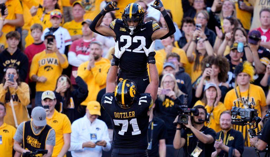 Iowa running back Braeden Jackson (22) celebrates with offensive lineman Jack Dotzler (71) after scoring a touchdown during the second half of an NCAA college football game against Ohio State, Saturday, Oct. 3, 2026, in Iowa City, Iowa. (AP Photo/Charlie Neibergall)