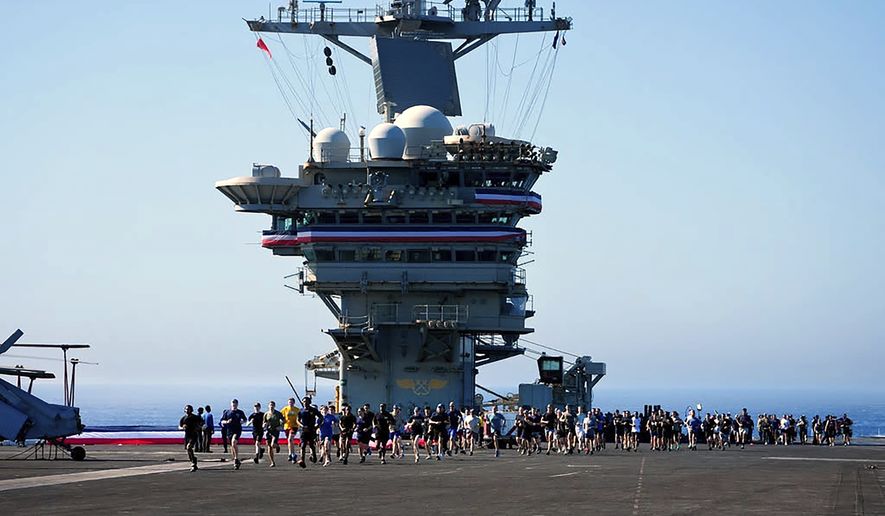 Crew members take part in a traditional 5K run, called the Ship to Shore 5K Scramble, doing several laps on the flight deck of the U.S. Abraham Lincoln's on Wednesday, Oct. 7, 2026, on their return to its home port at Naval Air Station North Island in San Diego, Calif. (Nelvin C. Cepeda/The San Diego Union-Tribune via AP)