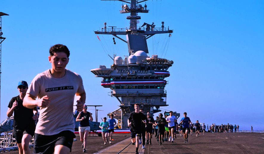 Crew members take part in a traditional 5K run, called the Ship to Shore 5K Scramble, doing several laps on the flight deck of the U.S. Abraham Lincoln's on Wednesday, Oct. 7, 2026, on their return to its home port at Naval Air Station North Island in San Diego, Calif. (Nelvin C. Cepeda/The San Diego Union-Tribune via AP)