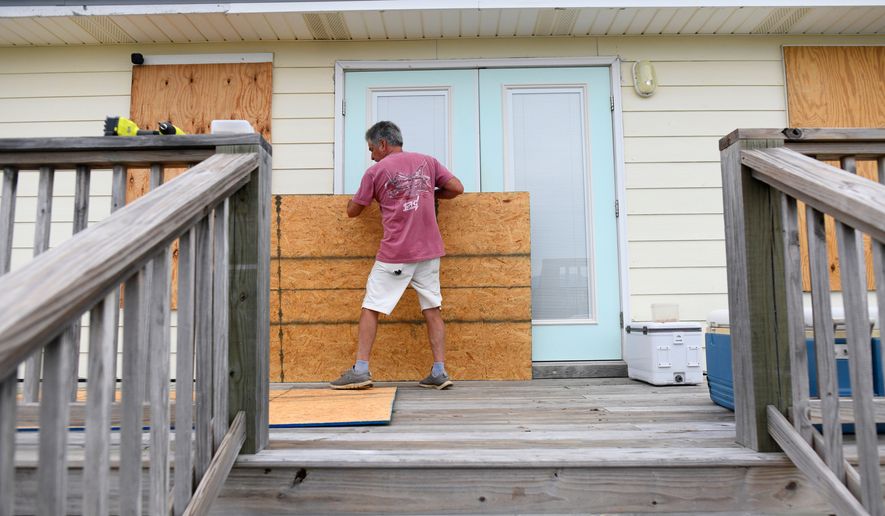 Larry Smith boards up his home with plywood ahead of Hurricane Isaias' expected landfall along the Gulf Coast in Dauphin Island, Alabama, Thursday, Oct. 8, 2026. (AP Photo/Octavio Jones)