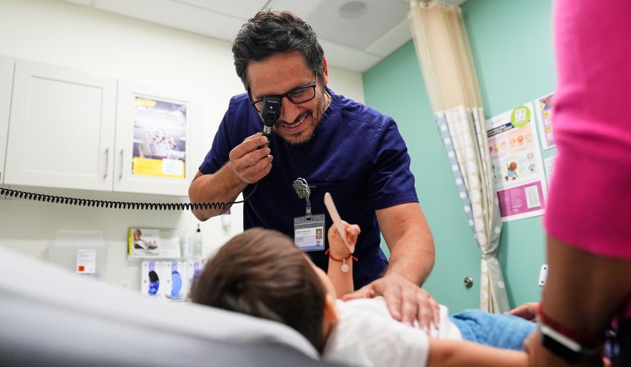 Pediatrician Irving Phillips examines a 16-month-old boy at a CommuniCARE+OLE clinic, June 26, 2025, in Davis, Calif. (AP Photo/Godofredo A. Vásquez, File)