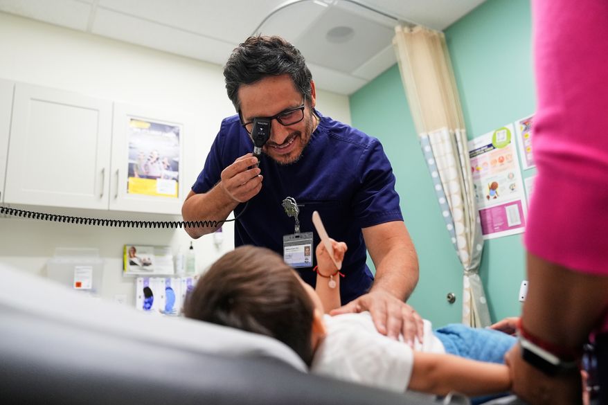 Pediatrician Irving Phillips examines a 16-month-old boy at a CommuniCARE+OLE clinic, June 26, 2025, in Davis, Calif. (AP Photo/Godofredo A. Vásquez, File)