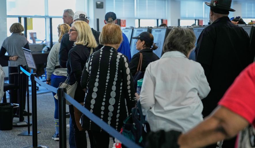 Voters wait in line to receive their ballots at early in-person voting in Cleveland, Wednesday, Oct. 7, 2026. (AP Photo/Sue Ogrocki)