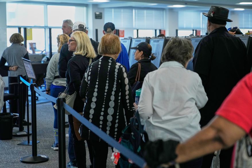 Voters wait in line to receive their ballots at early in-person voting in Cleveland, Wednesday, Oct. 7, 2026. (AP Photo/Sue Ogrocki)