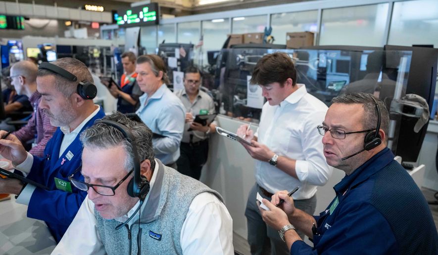 Options traders, including Marty Handler, foreground, and Matt Hefter, right, work on the floor of the New York Stock Exchange, Thursday, Oct. 8, 2026, in New York. (AP Photo/Yuki Iwamura)