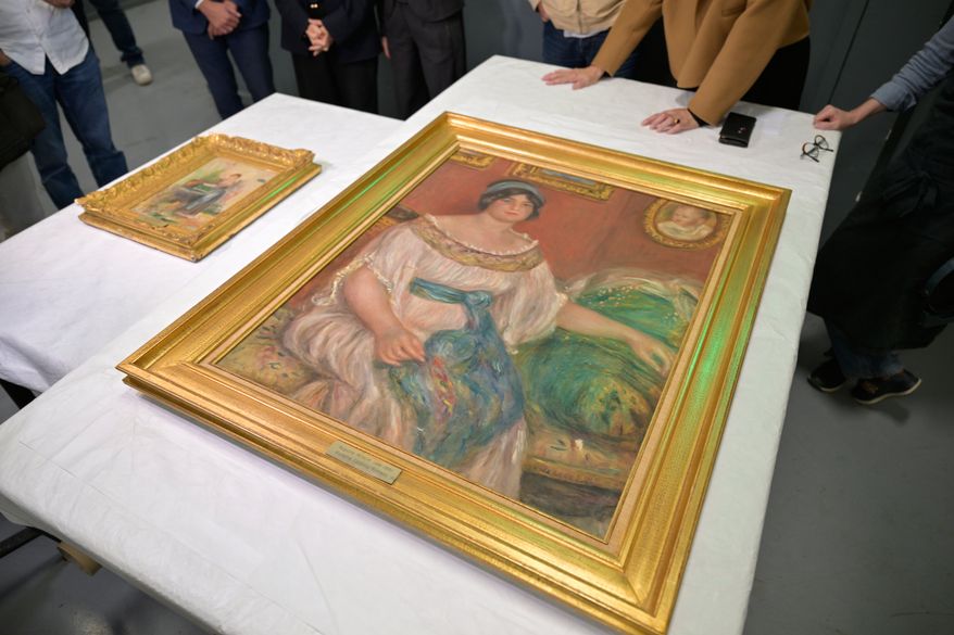 Recovered paintings "Portrait of Madame Colonna Romano", right, and "Young Woman at the Well," stolen from the Renoir Museum in Cagnes-sur-Mer are on display at the Interdisciplinary Centre for the Conservation and Restoration of Heritage in Marseille, France, Monday Oct. 12, 2026. (AP Photo/Philippe Magoni)