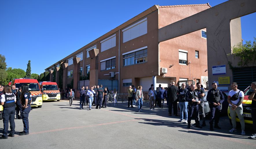 Police officers stand in front the Joseph Lakanal middle school after police have detained a 14-year-old pupil suspected in a rare school shooting, in Aubagne, France, Monday Oct. 12, 2026. (AP Photo/Philippe Magoni)