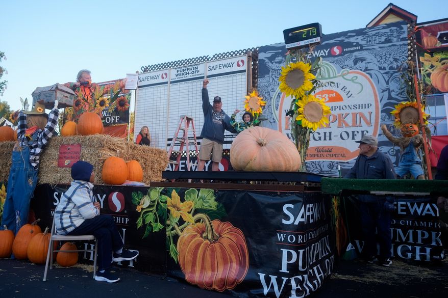 Jesus Cruzaley, 10, midde right, celebrates with his grandfather, Harold Stern, after his pumpkin was weighed at the Safeway World Championship Pumpkin Weigh-Off, Monday, Oct. 12, 2026, in Half Moon Bay, Calif. (AP Photo/Jeff Chiu)