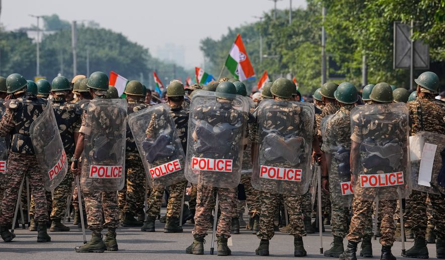 Security personnel in riot gear arrive to escort workers of India's opposition Congress party as they gather for a march toward the Supreme Court demanding the resignation of Chief Election Commissioner Gyanesh Kumar in New Delhi, India, Monday, Oct. 12, 2026. (AP Photo/Manish Swarup)