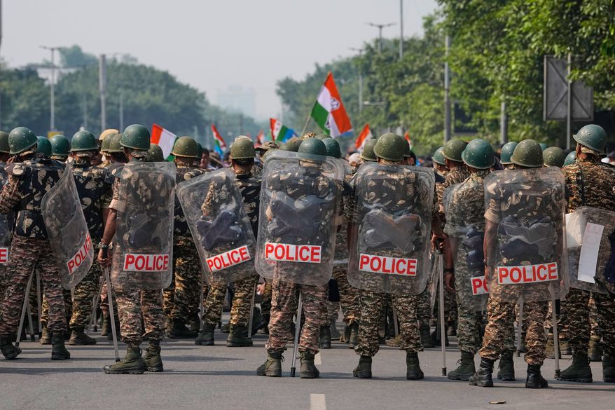 Security personnel in riot gear arrive to escort workers of India's opposition Congress party as they gather for a march toward the Supreme Court demanding the resignation of Chief Election Commissioner Gyanesh Kumar in New Delhi, India, Monday, Oct. 12, 2026. (AP Photo/Manish Swarup)