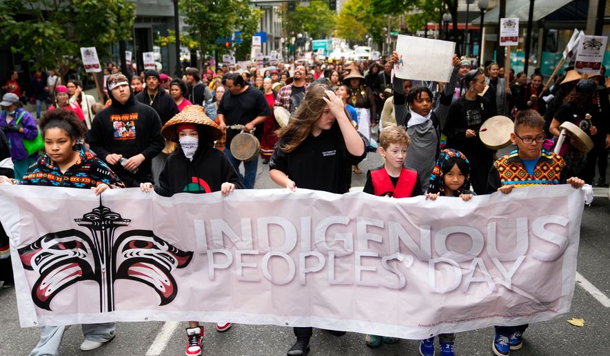 FILE - Young people hold a banner as they lead a celebratory march for Indigenous Peoples Day, Oct. 9, 2023, in Seattle. (AP Photo/Lindsey Wasson, file)