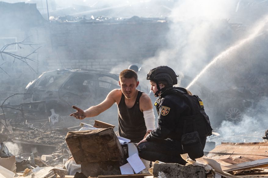 An injured man collects his personal belongings in front of his house destroyed in a Russian strike on Kharkiv, Ukraine, Sunday, Oct. 11, 2026. (AP Photo/Andrii Marienko)