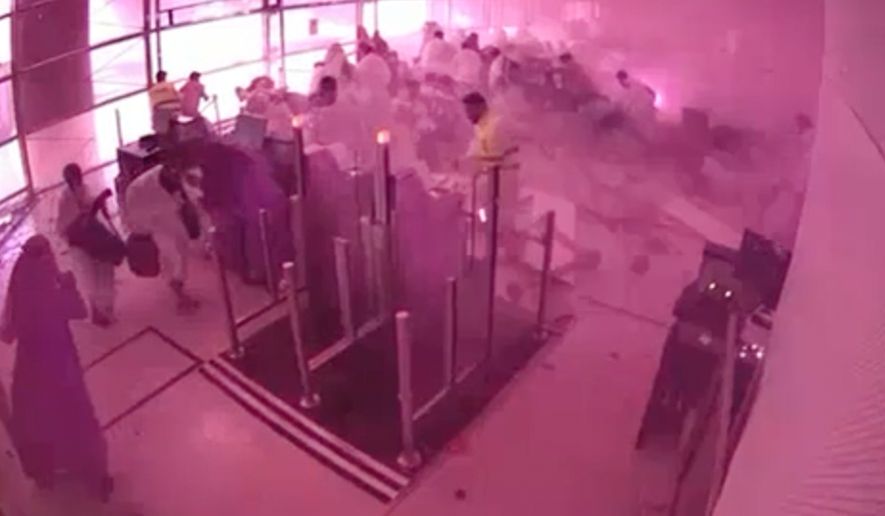 This image from CCTV video released by Saudi Arabia's Media Ministry shows passengers taking cover as flames and smoke fill part of King Khalid International Airport in Riyadh, Saudi Arabia, during what authorities described as a strike at the airport on Saturday, Oct. 10, 2026. (Saudi Media Ministry via AP)