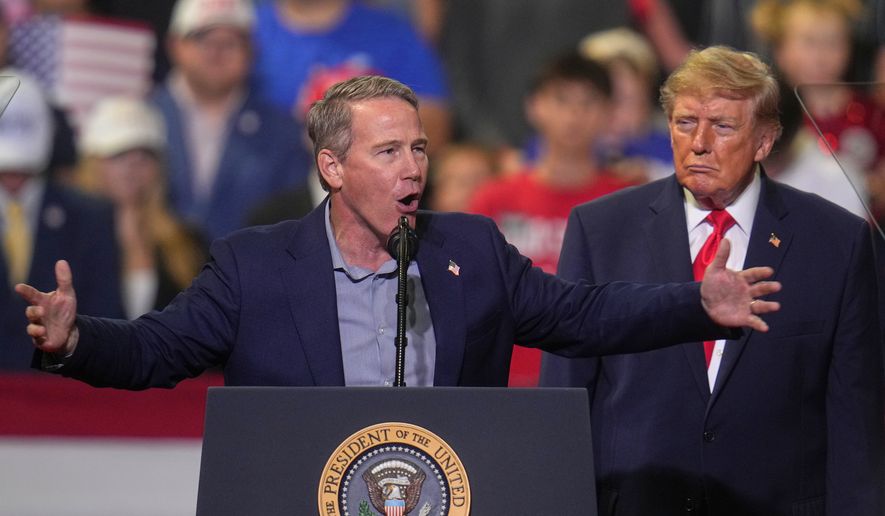 President Donald Trump listens as Sen. Jon Husted, R-Ohio, speaks at a campaign rally at the Covelli Centre, in Youngstown, Ohio, Monday, Oct. 12, 2026. (AP Photo/Gene J. Puskar)