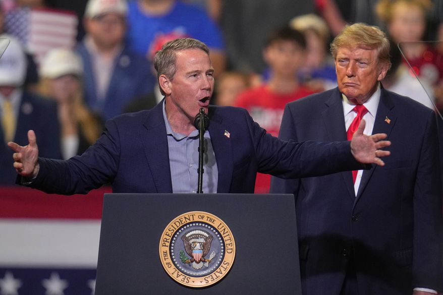 President Donald Trump listens as Sen. Jon Husted, R-Ohio, speaks at a campaign rally at the Covelli Centre, in Youngstown, Ohio, Monday, Oct. 12, 2026. (AP Photo/Gene J. Puskar)