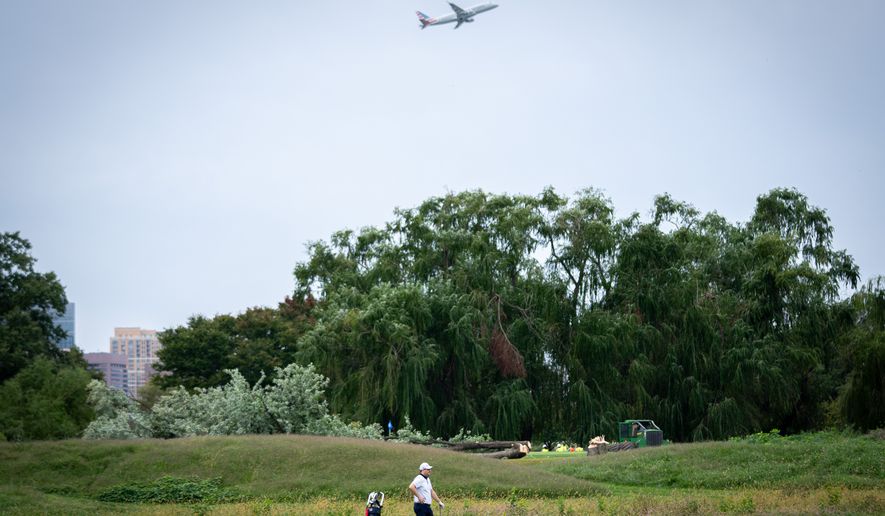 A golfer pauses near trees recently cut down by the National Park Service at East Potomac Golf Links, Saturday, Oct. 10, 2026, in Washington. (AP Photo/Nathan Howard)