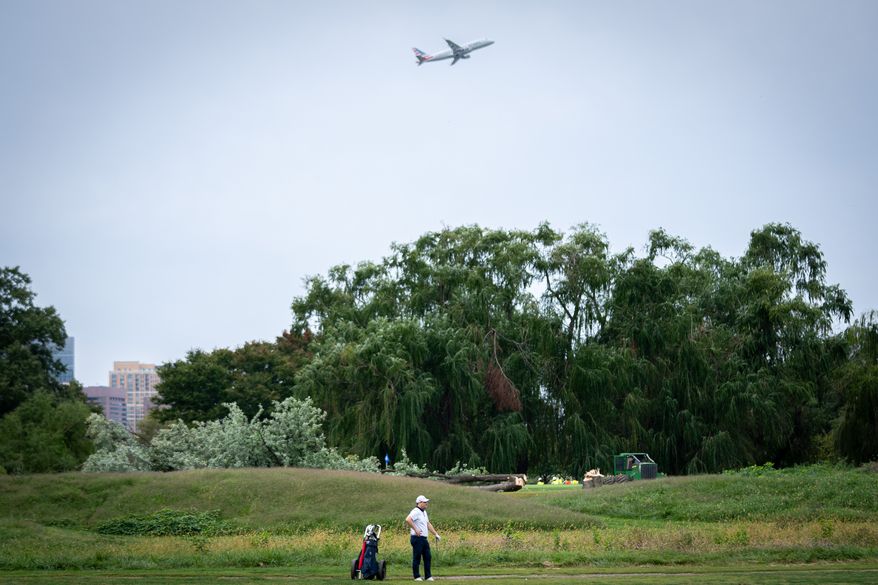 A golfer pauses near trees recently cut down by the National Park Service at East Potomac Golf Links, Saturday, Oct. 10, 2026, in Washington. (AP Photo/Nathan Howard)