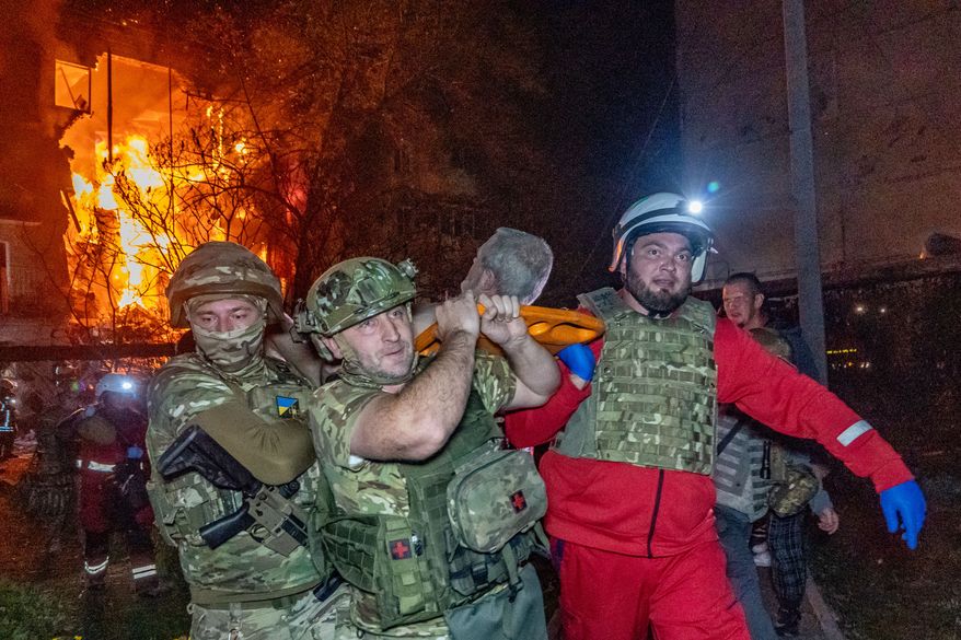 Rescuers evacuate an injured civilian after a residential building was hit following a Russian air attack in Kharkiv, Ukraine, Tuesday, Oct. 13, 2026. (AP Photo/Andrii Marienko)