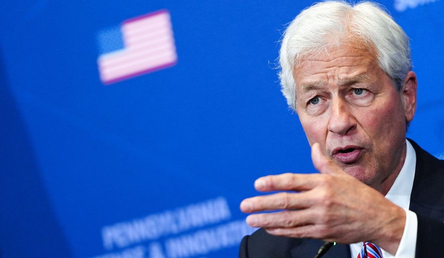 FILE - Jamie Dimon, chairman and CEO of JP Morgan Chase, listens as President Donald Trump speaks during a roundtable at the Pennsylvania Defense and Innovation Summit, Wednesday, July 15, 2026, at the United States Army War College in Carlisle, Pa. (AP Photo/Julia Demaree Nikhinson, File)