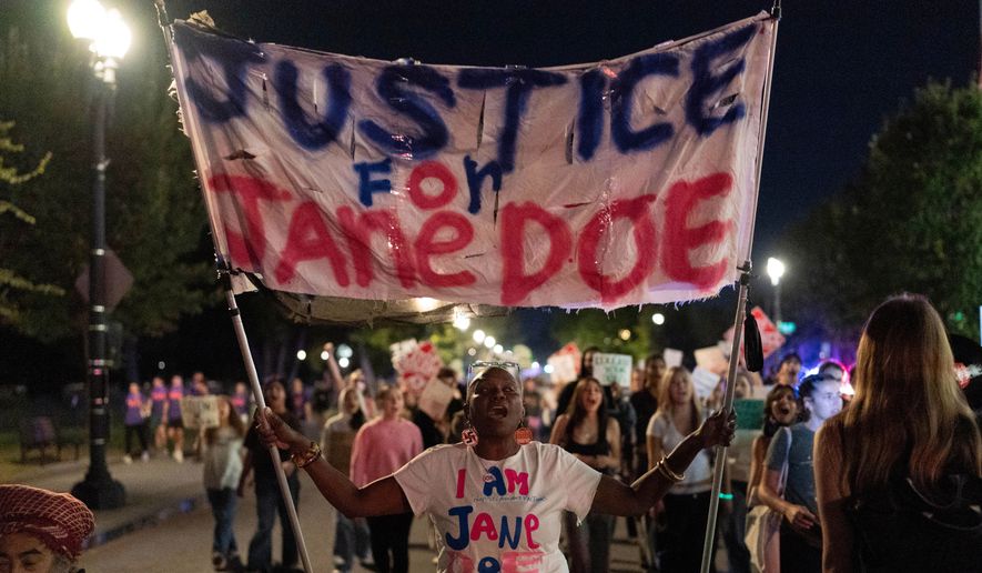 Demonstrators march from the Washington Monument to the White House during a "Stop Sexual Violence" protest in Washington, Thursday, Oct. 8, 2026. (AP Photo/Jose Luis Magana)