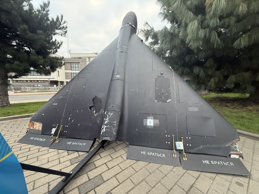 A downed Russian attack drone of the Iranian Shahed design, displayed by Ukraine's Independent Anti-Corruption Commission outside the Warsaw Security Forum in Warsaw, Poland, on Tuesday, Oct. 13, 2026. The Russian stencils on the control surfaces read "do not handle." (Jacob Wirtschafter/Special to The Washington Times)