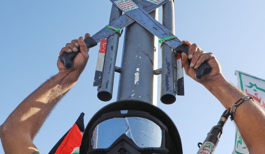 A Houthi supporter wearing a military uniform holds a mock missile during a rally in support of the group, in Sanaa, Yemen, Friday, Oct. 9, 2026. (AP Photo/Osamah Abdulrahman)