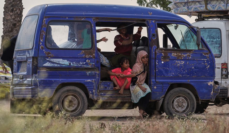 Displaced Yemeni children sit in a vehicle as families gather to receive aid at the Al-Fallahine displacement camp in Dar Saad district, Aden, Yemen, Monday, Oct. 12, 2026. (AP Photo/Abdulnasser Alseddik)