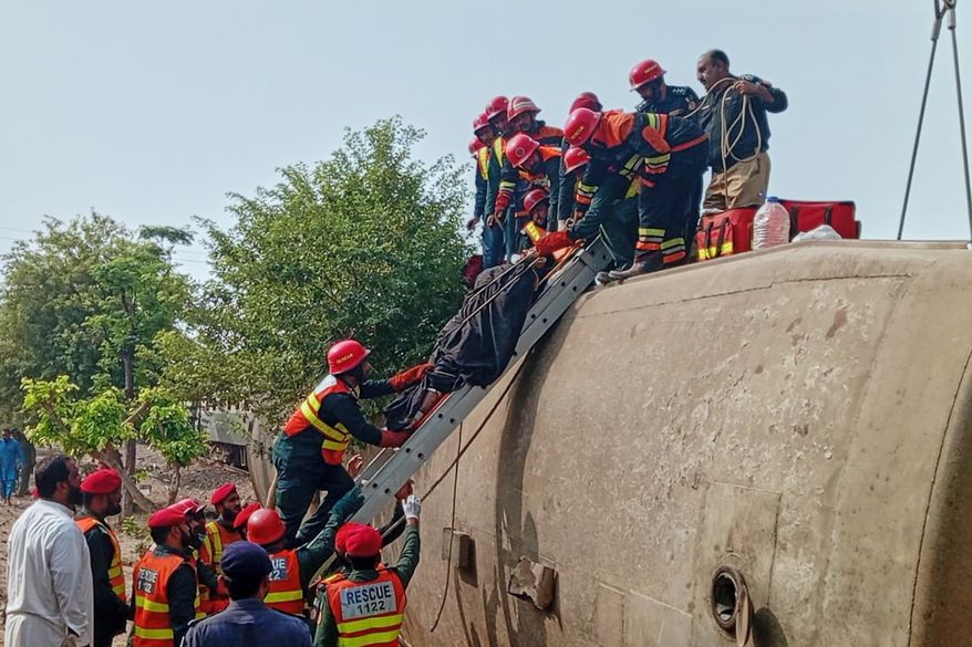 In this photo released by the Rescue 1122 Emergency Department, rescue workers recover an injured person from a derailed coach on the outskirts of Multan, in central Pakistan, Tuesday, Oct. 13, 2026. (Rescue 1122 Emergency Department via AP)