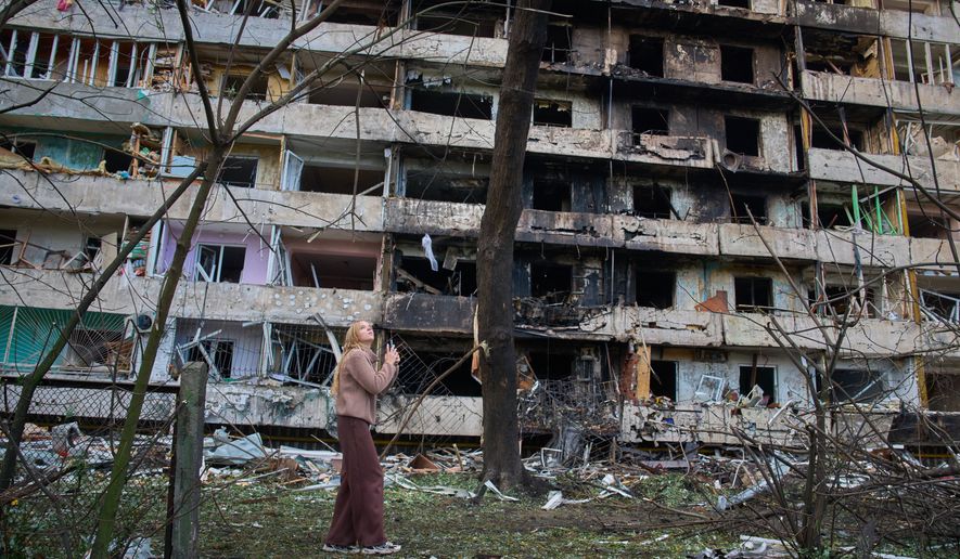 A young woman reacts as she looks at her damaged home after Russia's night missile attack in Kyiv, Ukraine, Wednesday, Oct. 14, 2026. (AP Photo/Efrem Lukatsky)