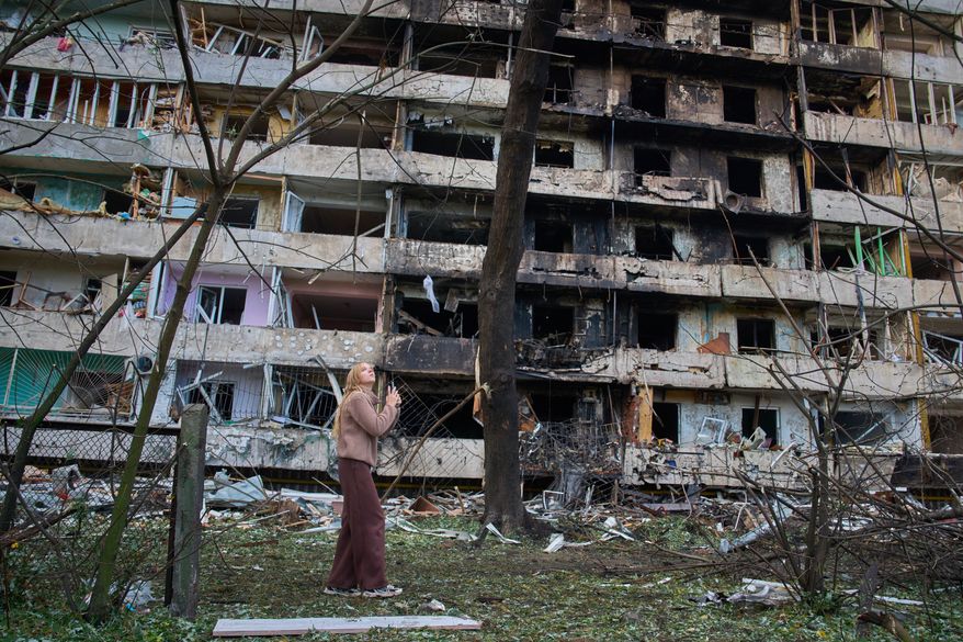 A young woman reacts as she looks at her damaged home after Russia's night missile attack in Kyiv, Ukraine, Wednesday, Oct. 14, 2026. (AP Photo/Efrem Lukatsky)