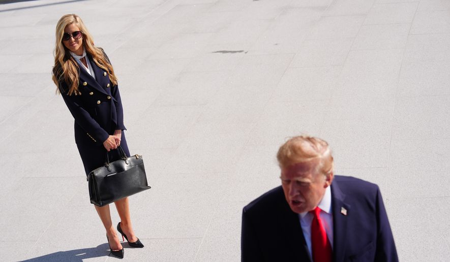 President Donald Trump speaks to the reporters as he walks to board Marine One on the South Lawn of the White House, Tuesday, Oct. 13, 2026, in Washington, as White House press secretary Katie Zacharia looks on. (AP Photo/Julia Demaree Nikhinson)