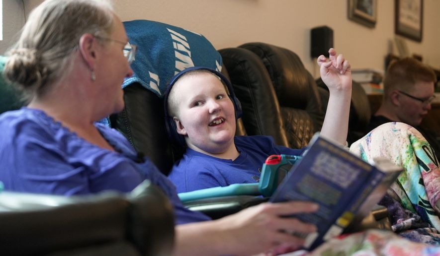 William Walter, 11, and his mother, Katherine, read a book together during homeschooling hours in White Sulphur Springs, Mont., July 16, 2026. (AP Photo/Shelby Lum)