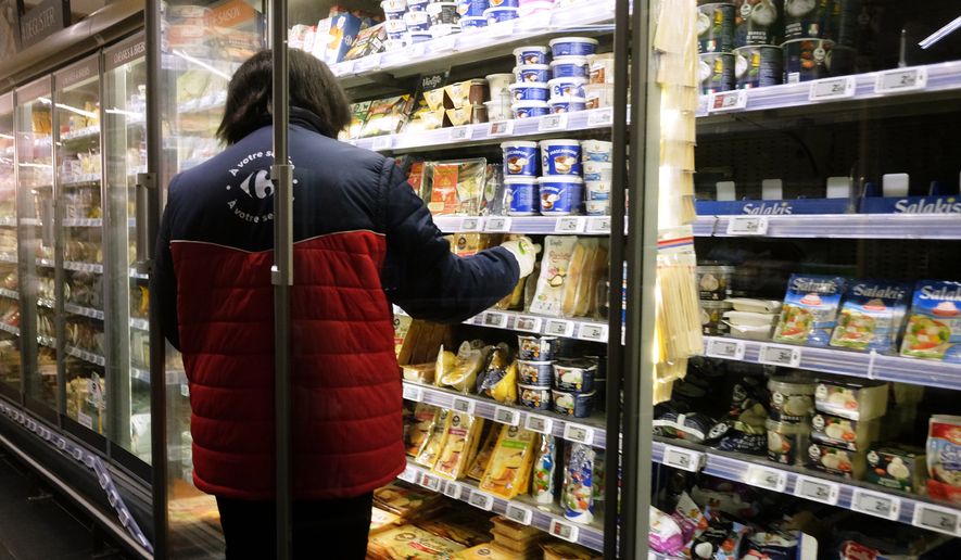 A worker restocking products in a refrigerated section of a supermarket two days after the cyberattack on several French supermarkets in Montreuil, France, Wednesday, Oct. 14, 2026. (AP Photo/Teresa Suarez)