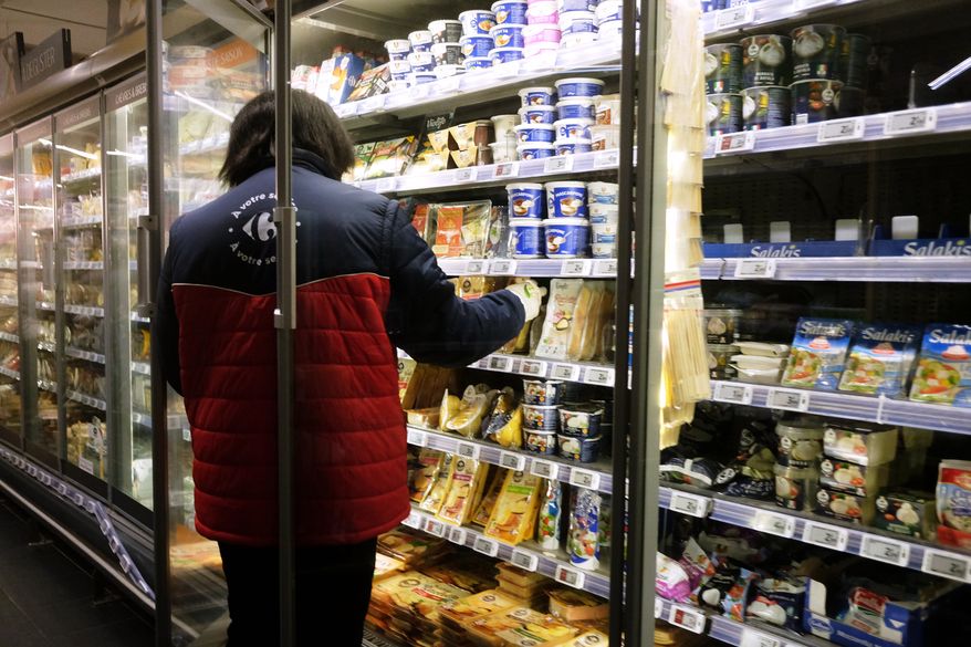 A worker restocking products in a refrigerated section of a supermarket two days after the cyberattack on several French supermarkets in Montreuil, France, Wednesday, Oct. 14, 2026. (AP Photo/Teresa Suarez)