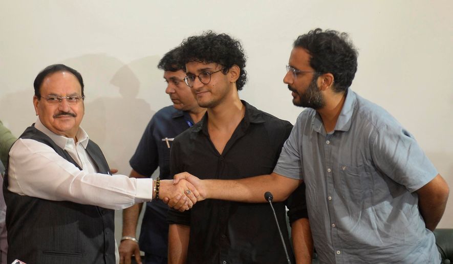 FILE -Saurav Das, chief spokesperson of the Cockroach Janta Party, center, looks on as fellow spokesperson Ashutosh Ranka, right, shakes hands with India's Health Minister J.P. Nadda during a joint press conference in New Delhi, India, July 25, 2026, following the resignation of India's education minister. (AP Photo), File)