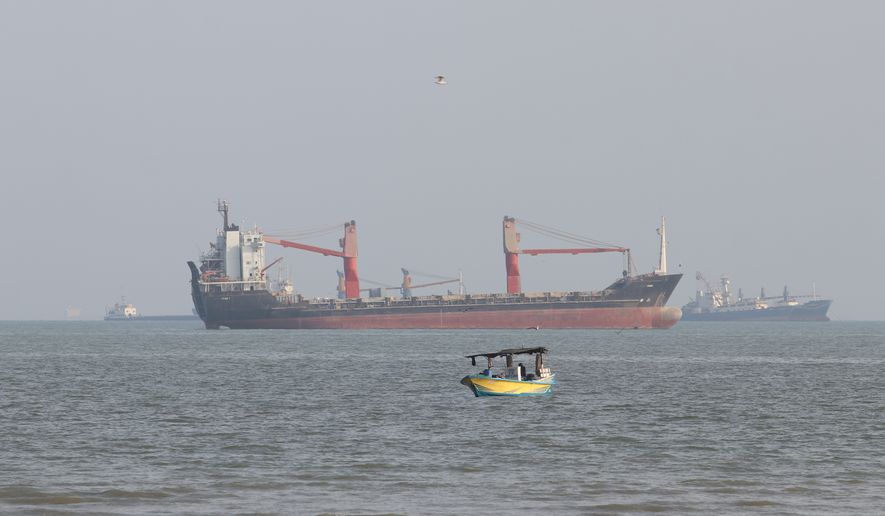 A boat floats as commercial vessels appear anchored in the Strait of Hormuz off Bandar Abbas, Iran, Tuesday, Oct. 13, 2026. (Razieh Poudat/ISNA via AP)
