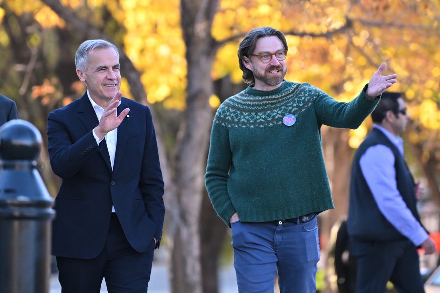Prime Minister Mark Carney, left, arrives with Executive Director of Public Interest Alberta Brad Lafortune to meet volunteers at Bridgeland Riverside Community Association Park in Calgary, Alberta, on Thursday Oct. 15, 2026. (Mike Sturk/The Canadian Press via AP)